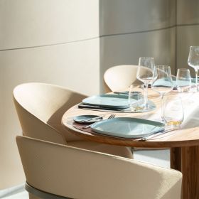 Light-filled room with bright chairs and elegantly laid table in LUX.