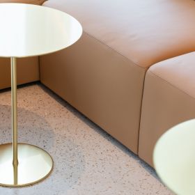 Close-up of light leather furniture with golden table.