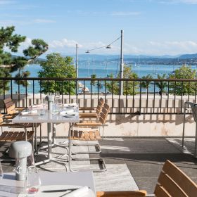 Beautiful restaurant terrace with covered tables and a breathtaking view of the lake.